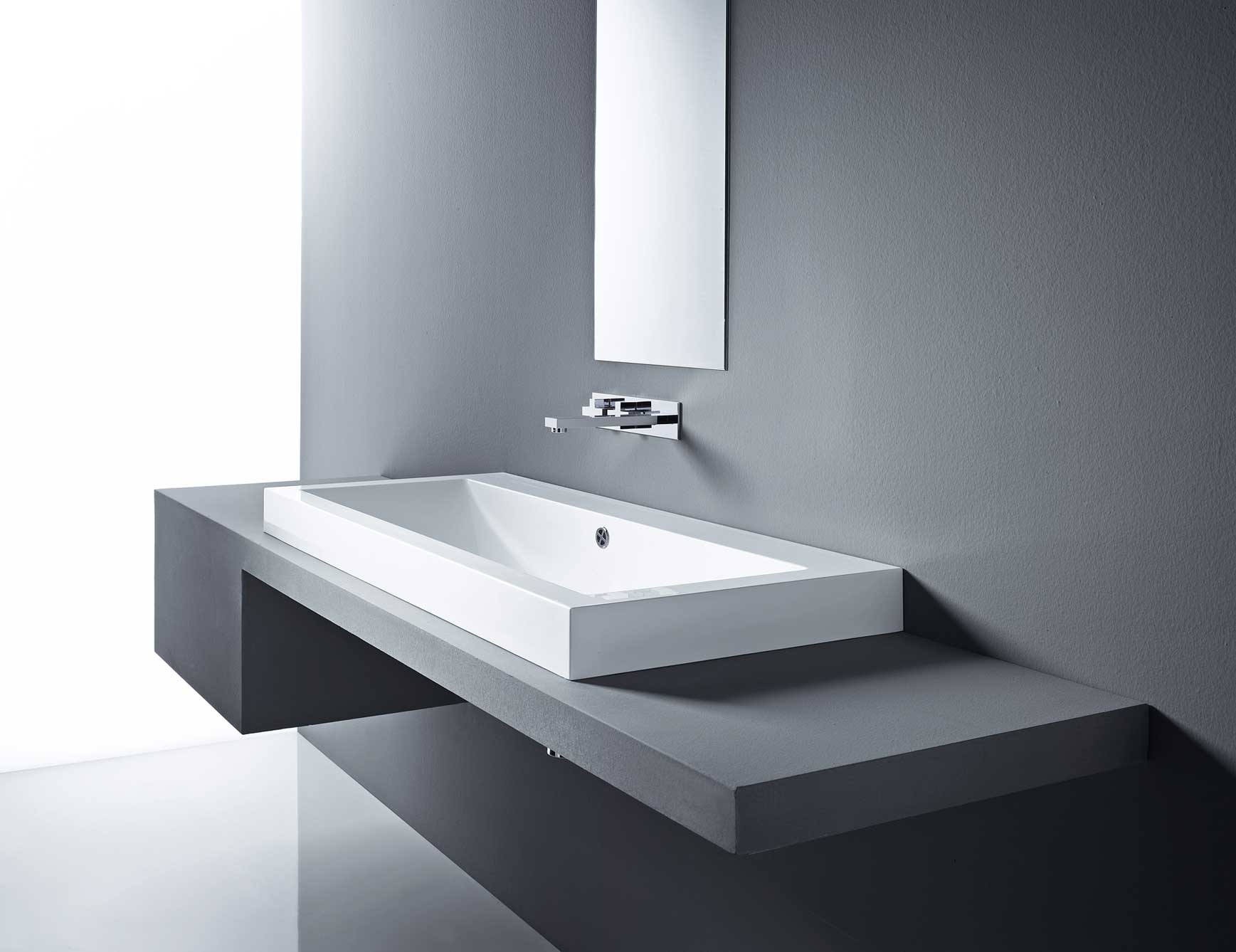 Rectangular white ceramic sink on gray wall-mounted counter